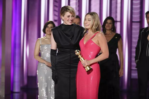 En esta imagen proporcionada por CBS, la directora Greta Gerwig, izquierda, y la actriz Margot Robbie reciben el premio al logro cinematográfico y de taquilla por “Barbie” en la 81a edición de los Globos de Oro el domingo 7 de enero de 2024, en el Hotel Beverly Hilton en Beverly Hills, California. (Sonja Flemming/CBS via AP) (Sonja Flemming / Associated Press)