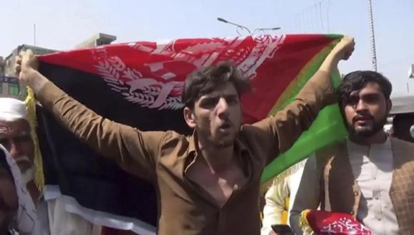 Un hombre sostiene la bandera de Afganistán durante una protesta en Jalalabad el miércoles 18 de agosto de 2021. Militantes talibanes atacaron a los manifestantes. (Foto AP).