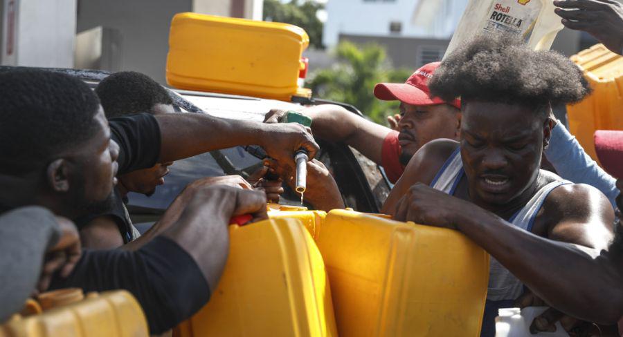 La gente empuja y empuja mientras intentan llenar sus tanques de gasolina en una estación de servicio en Puerto Príncipe, Haití. (AP/ Odelyn Joseph).