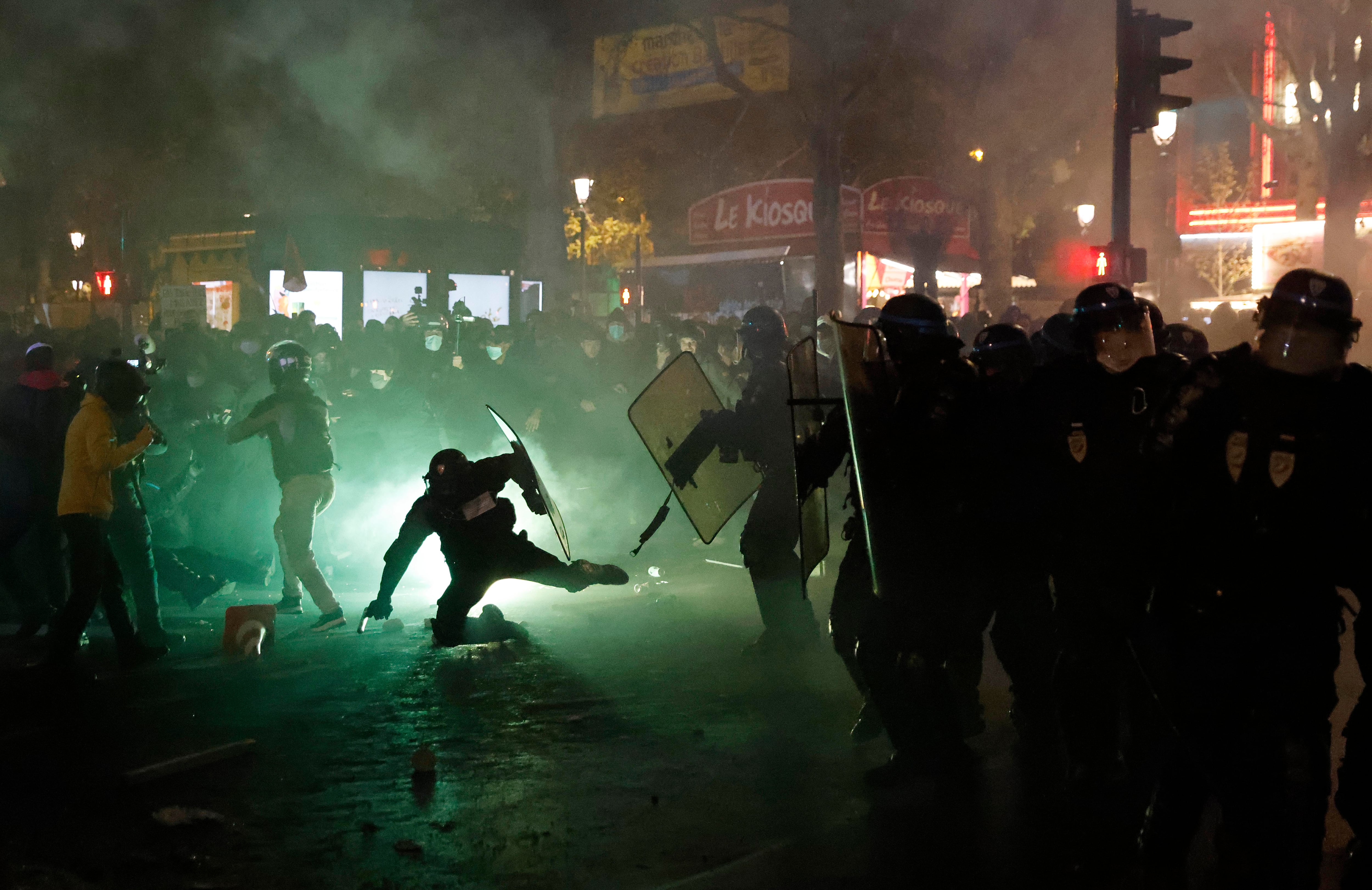 La policía antidisturbios francesa se enfrenta a protestantes durante una manifestación contra el proyecto de ley de 'seguridad global', cuyo artículo 24 penalizaría la publicación de imágenes de agentes de policía en servicio con la intención de dañar su "integridad física o psicológica'', en París. Se planean decenas de manifestaciones contra una nueva ley francesa que restringiría el intercambio de imágenes de la policía, solo días después de que el país se viera sacudido por imágenes que mostraban a agentes golpeando y abusando racialmente a un hombre negro. (Foto: Thomas Coex / AFP)