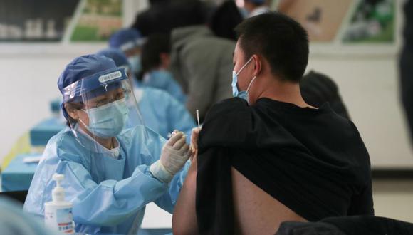 Un trabajador médico (izquierda) administra una vacuna contra el coronavirus Covid-19 a un hombre en un centro de vacunación temporal en Beijing. (Foto: China OUT / AFP / CNS / STR).
