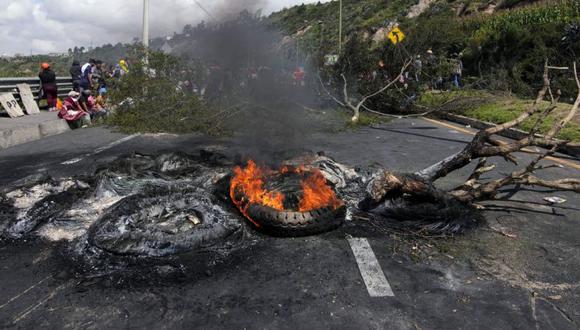 Neumáticos quemados y árboles bloquean la carretera Panamericana Norte en apoyo a la movilización nacional contra el gobierno ecuatoriano en la comuna de San Miguel del Común, Quito.