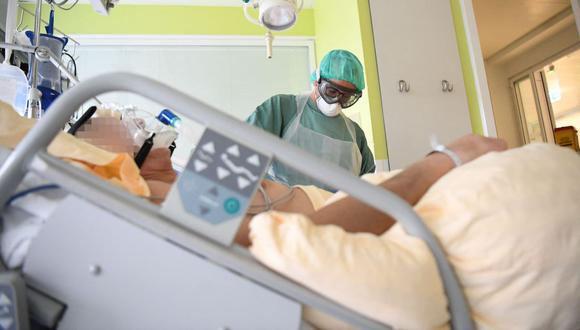 Un trabajador de la salud que usa equipo de protección personal (EPP) trata a un paciente de coronavirus en una unidad de cuidados intensivos del Hospital Universitario Tulln en Viena, Austria, el 27 de noviembre de 2020. (HELMUT FOHRINGER / APA / AFP).