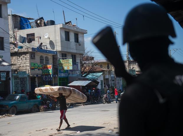 Un policía vigila cuando la tensión volvió este viernes a Puerto Príncipe con tiroteos entre las fuerzas del orden y las bandas armadas. (EFE/ Johnson Sabin).