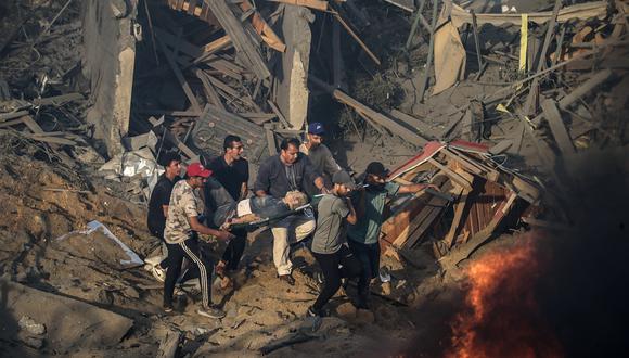 Palestinos transportan a un hombre herido en una camilla lejos de un incendio que arde en una zona destruida tras los ataques aéreos israelíes en la ciudad de Gaza, el 25 de octubre de 2023. (Foto de EFE/EPA/MOHAMMED SABER)