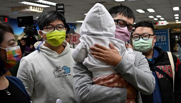 Imagen de archivo | La pareja gay taiwanesa Chen Jun-ru (derecha), con su hija en brazos, y Wang Chen-wei (izquierda) llegan a la oficina del distrito de Xinyi en Taipei el 13 de enero de 2022. (Foto de Sam Yeh / AFP)