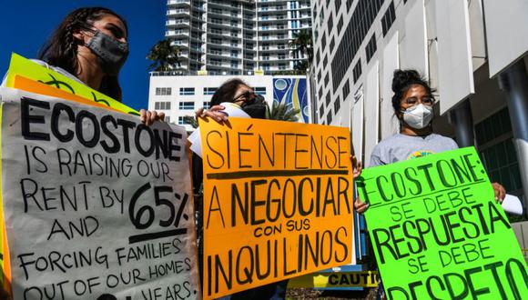 Miembros del Centro de Trabajadores de Miami Norma Uriostegui (dere.) Lizzie Suarez (izq.) y la inquilina Maria Ruby (Centro) protestan contra los aumentos de alquiler frente al edificio de oficinas de un propietario en Miami, Florida. (Foto: CHANDAN KHANNA / AFP).