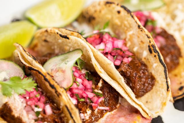 Tacos de barbacoa (asado de tira en adobo, queso Oaxaca y sour cream en tortilla de maíz)