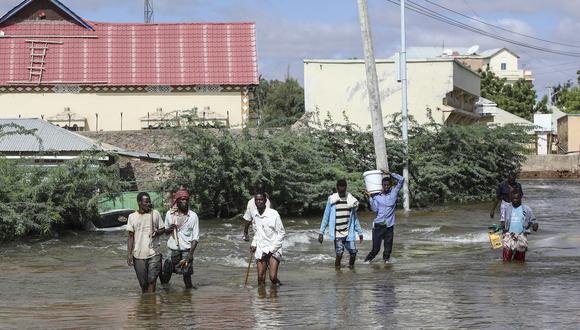 Los hombres caminan a través de las inundaciones en Beledweyne, en el centro de Somalia, el 13 de mayo de 2023. (Foto de Hassan Ali ELMI / AFP)