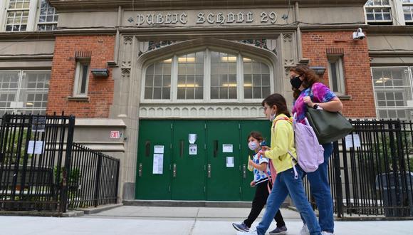 Los estudiantes pasan por una escuela pública el 5 de octubre de 2020 en el distrito de Brooklyn, Nueva York, en plena pandemia de coronavirus. (ANGELA WEISS / AFP).