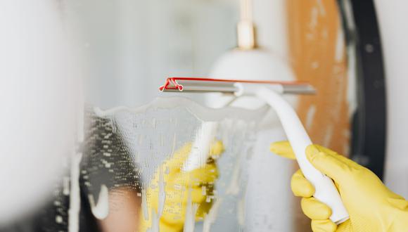 Persona limpiando el espejo del cuarto de baño. (Imagen: Karolina Grabowska / Pexels)