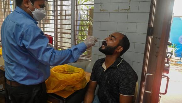 Trabajador de la salud sacando una prueba del coronavirus en Nueva Delhi. (Photo by Prakash SINGH / AFP)