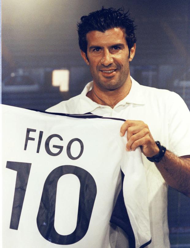 Portuguese soccer player Luis Figo holds up the Real Madrid shirt he will be wearing next season after being presented to the press at the Bernabeu stadium in Madrid, Spain, Monday, July 24, 2000. Figo formerly played in Barcelona. (AP Photo/Zaheeruddin Abdullah)