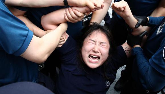 Una manifestante en Corea del Sur es arrestada por la policía en medio de una protesta contra el vertimiento de aguas residuales de la planta nuclear de Fukushima. (Getty Images).