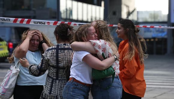 La gente reacciona fuera del centro comercial Fields durante la evacuación por parte de la policía armada, en Oerstad, Copenhague, Dinamarca.