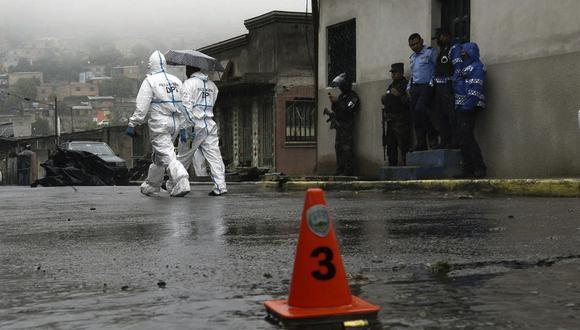 Elementos de la Policía Nacional y peritos forenses laboran en la escena del crimen donde el periodista Edwin Josué Andino, en la colonia Villafranca, Tegucigalpa, el 10 de octubre de 2022. (Foto por Orlando SIERRA / AFP)