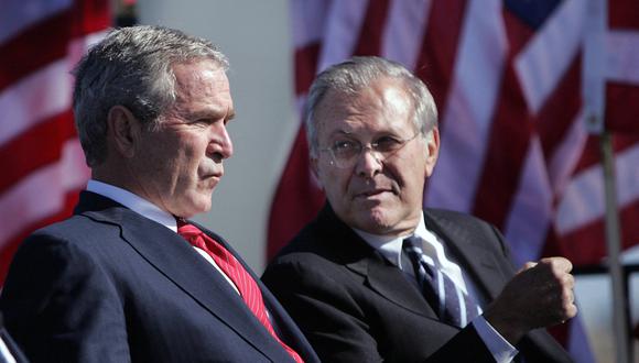 En esta foto de archivo tomada el 14 de octubre de 2006, el presidente estadounidense George W. Bush (izq.) conversa con el secretario de Defensa Donald Rumsfeld. (Foto de Tim SLOAN / AFP).