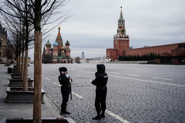 Oficiales de policía con máscaras patrullan en la vacía Plaza Roja, con la Catedral de San Basilio y la Torre Spasskaya del Kremlin al fondo, en Moscú. (Foto: AFP/Dimitar Dilkoff)