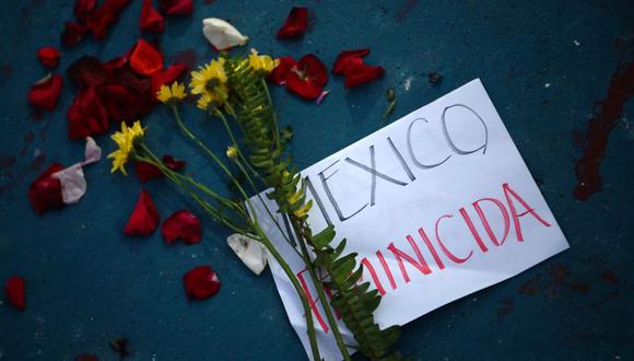 Flores y carteles que dicen "Feminicidio en México" se muestran en un memorial improvisado durante una manifestación llamada "Justicia para Victoria" por la muerte de la salvadoreña Victoria Esperanza Salazar en San Salvador, el 29 de marzo de 2021. (Foto de MARVIN RECINOS / AFP)