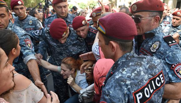 Agentes de policía detienen a un manifestante durante una manifestación antigubernamental en el centro de Ereván, tras las operaciones militares azerbaiyanas contra las fuerzas separatistas armenias en Nagorno-Karabaj. (Foto de Karen MINASYAN / AFP)