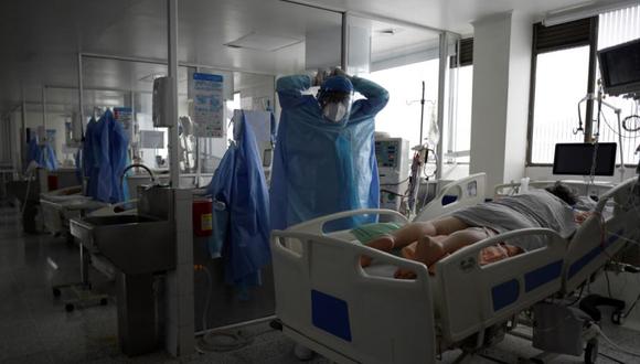 Un trabajador de la salud se prepara antes de asistir a un paciente de Covid-19 en la Unidad de Cuidados Intensivos (UCI) del hospital El Tunal en Bogotá. (Foto: Raúl ARBOLEDA / AFP)
