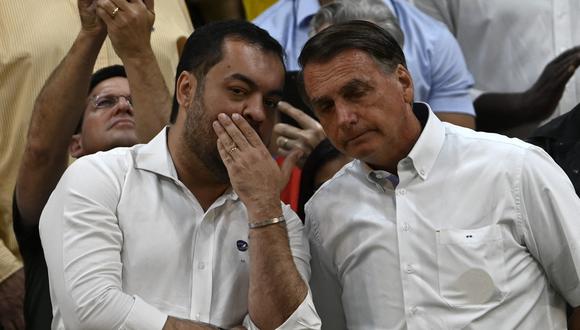 El gobernador de Río de Janeiro, Claudio Castro (izq.), susurra al presidente de Brasil, Jair Bolsonaro, en el gimnasio Maracanazinho de Río de Janeiro.