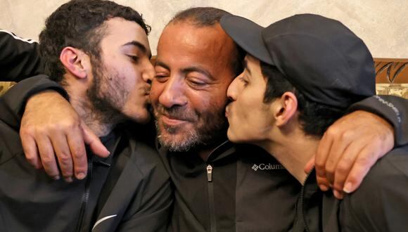 Los hermanos palestinos Qassam (L) y Nasrallah (R) se reúnen con su padre Iyad Al-Awar después de que ambos fueron liberados de una prisión israelí como parte de un acuerdo de rehenes entre Israel y Hamas, en su casa en Jerusalén Este, anexada por Israel, el 26 de noviembre. , 2023. (Foto de AHMAD GHARABLI / AFP)