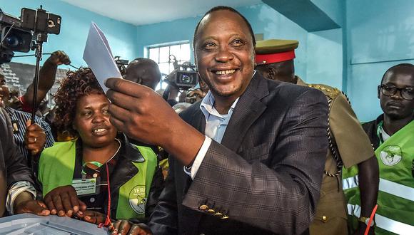 Kenya's President Uhuru Kenyatta holds a ballot paper at the polling station, during the August 8, 2017 presidential election in Gatundu, Kiambu county.  Kenyans began voting in general elections headlined by a too-close-to-call battle between incumbent Uhuru Kenyatta and his rival Raila Odinga, sparking fears of violence in east Africa's richest economy. / AFP / SIMON MAINA