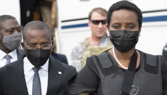 Imagen muestra al primer ministro, Claude Joseph, caminando con Martine Moise, viuda del asesinado presidente de Haití, Jovenel, cuando llega al aeropuerto Toussaint Louverture en Puerto Príncipe (Haití), el 17 de julio de 2021. (AFP).