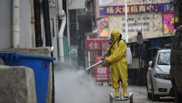 Un miembro del personal médico es captado rociando desinfectante en un área residencial en Wuhan, en la provincia central de Hubei, en China. (AFP)