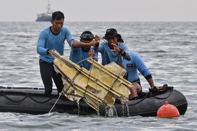 Buzos de la Armada de Indonesia sacan restos del vuelo SJY182 de Sriwijaya Air durante una operación de búsqueda y rescate en el mar cerca de la isla Lancang el 10 de enero de 2021. (Foto de ADEK BERRY / AFP).
