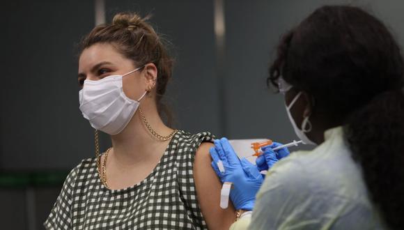 María Mercedes Sarmiento, de Perú, recibe una vacuna Pfizer-BioNtech COVID-19 de un trabajador de la salud en el Aeropuerto Internacional de Miami en Miami, Florida. (Foto: Joe Raedle / Getty Images / AFP).