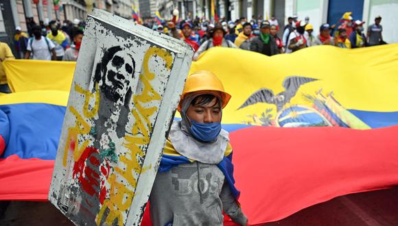 Indígenas marchan portando una bandera de Ecuador hacia el Palacio Presidencial de Carondelet, en Quito, el 27 de junio de 2022. (MARTIN BERNETTI / AFP).