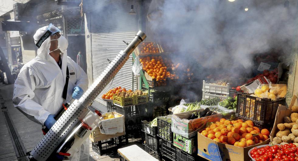 Un bombero desinfecta un mercado para ayudar a prevenir la propagación del nuevo coronavirus en el norte de Teherán, Irán. (Foto AP / Ebrahim Noroozi).