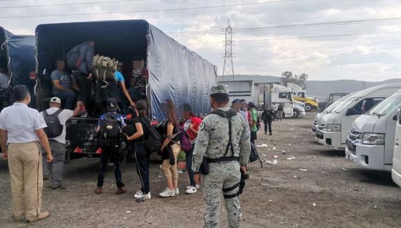 Las autoridades mexicanas observan a los migrantes, que fueron descubiertos en un puesto de control mientras viajaban en un tráiler, mientras subían a un autobús en Saltillo, México.