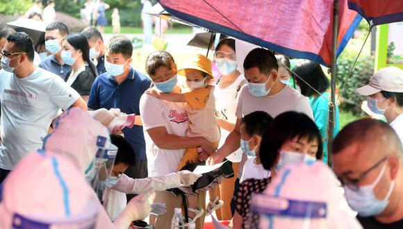 Personas se acercan a un lugar de descarte de coronavirus, en Wuhan. EFE