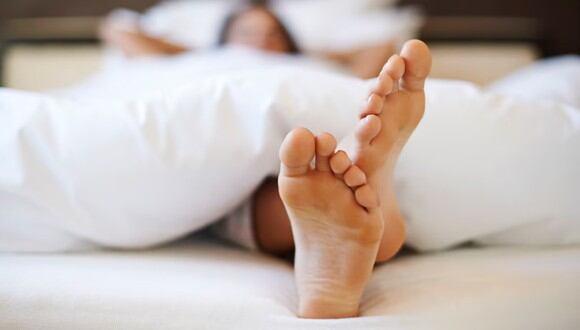Una mujer mostrando sus pies encima de la cama. | Imagen referencial: gpoinstudio / Freepik