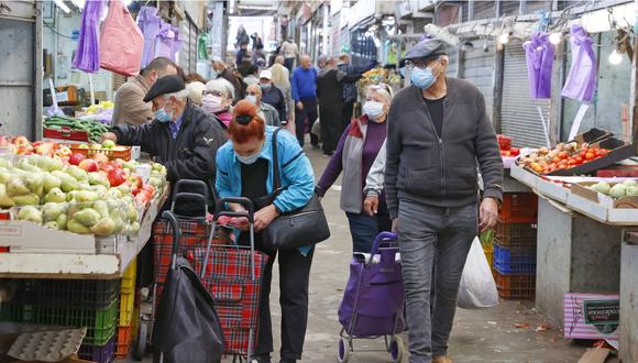 Israelíes, con mascarillas debido a la pandemia de COVID-19, compran en el mercado central de la ciudad costera de Netanya en Israel, el 27 de diciembre de 2020. (Foto: Jack Guez/ AFP).