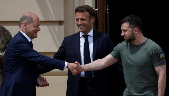 El presidente ucraniano, Volodymyr Zelenskiy, le da la mano al canciller alemán, Olaf Scholz, mientras el presidente francés Emmanuel Macron observa fuera del Palacio Mariyinsky. (REUTERS/Valentyn Ogirenko)