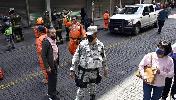 Bomberos y rescatistas observan los daños en un edificio tras un terremoto en la Ciudad de México el 19 de septiembre de 2022. (Foto de Alfredo ESTRELLA / AFP)