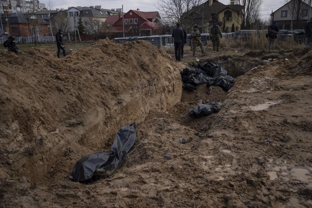Journalists stand next to a mass grave in Bucha, outside kyiv, Ukraine, Monday, April 4, 2022. (AP Photo/Rodrigo Abd)