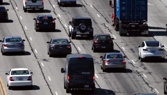 Una furgoneta de reparto de Amazon (C) pasa por delante de automóviles, camiones, SUV y otros vehículos en el tráfico en la autopista 405 a través del paso Sepúlveda en Los Ángeles, California, el 25 de agosto de 2022. (Foto de Patrick T. FALLON / AFP)