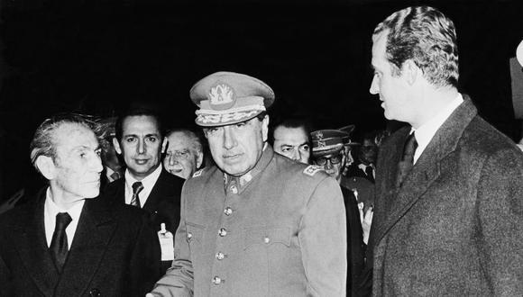 El dictador chileno Augusto Pinochet (C) recibido en el aeropuerto de Barajas en Madrid para asistir al funeral de Franco. (Foto de AFP)