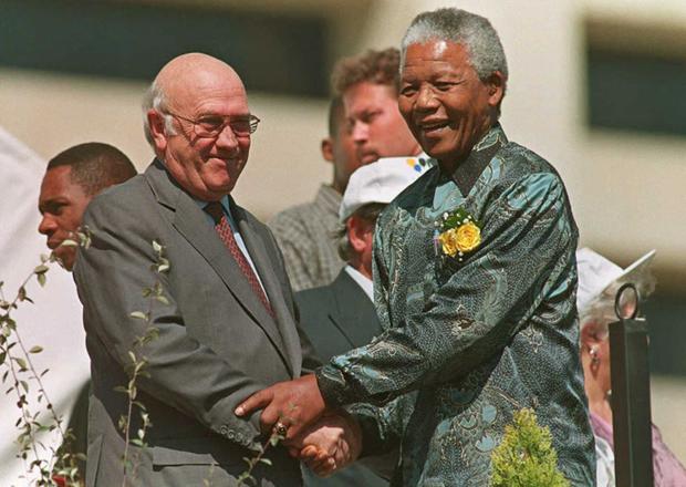 In this file photo taken on April 27, 1996, President Nelson Mandela holds the hand of Vice President Frederik de Klerk.