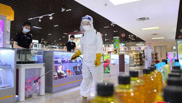 Un miembro del personal desinfectando las instalaciones para evitar la propagación del coronavirus Covid-19 en una tienda de Pyongyang. (Foto de varias fuentes / AFP)