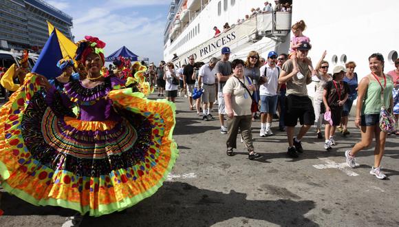 Un grupo de Palenqueras dan la bienvenida a los turistas que descienden de cruceros atracados en Cartagena, Colombia, el 3 de enero de 2011. (Foto de AFP).