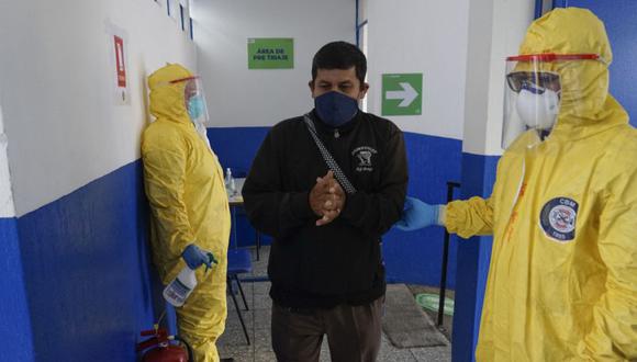 Un paciente con síntomas del nuevo coronavirus es acompañado por un bombero municipal para una consulta médica virtual en un Campamento del Centro de Bienestar Respiratorio en el barrio Quinta Samayoa, en la Ciudad de Guatemala. (Foto: Johan ORDONEZ / AFP).