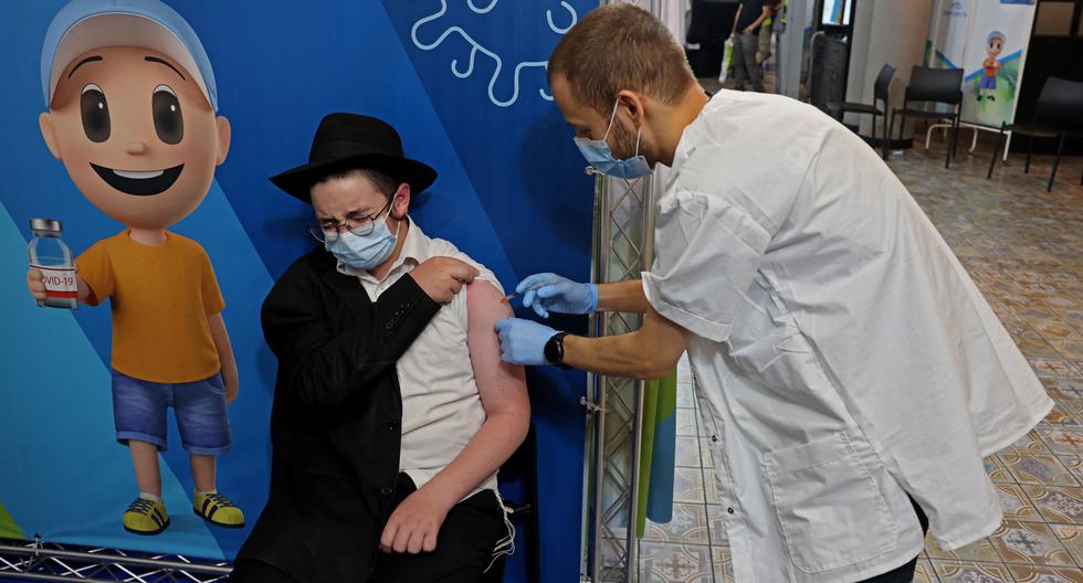 Un trabajador sanitario de Israel administra una tercera dosis de la vacuna contra el coronavirus COVID-19 de Pfizer en el nuevo centro de vacunación de los Servicios de Salud Clalit en el complejo Cinema City de Jerusalén. El avance de la variante ómicron preocupa a las autoridades. (Foto: AFP)