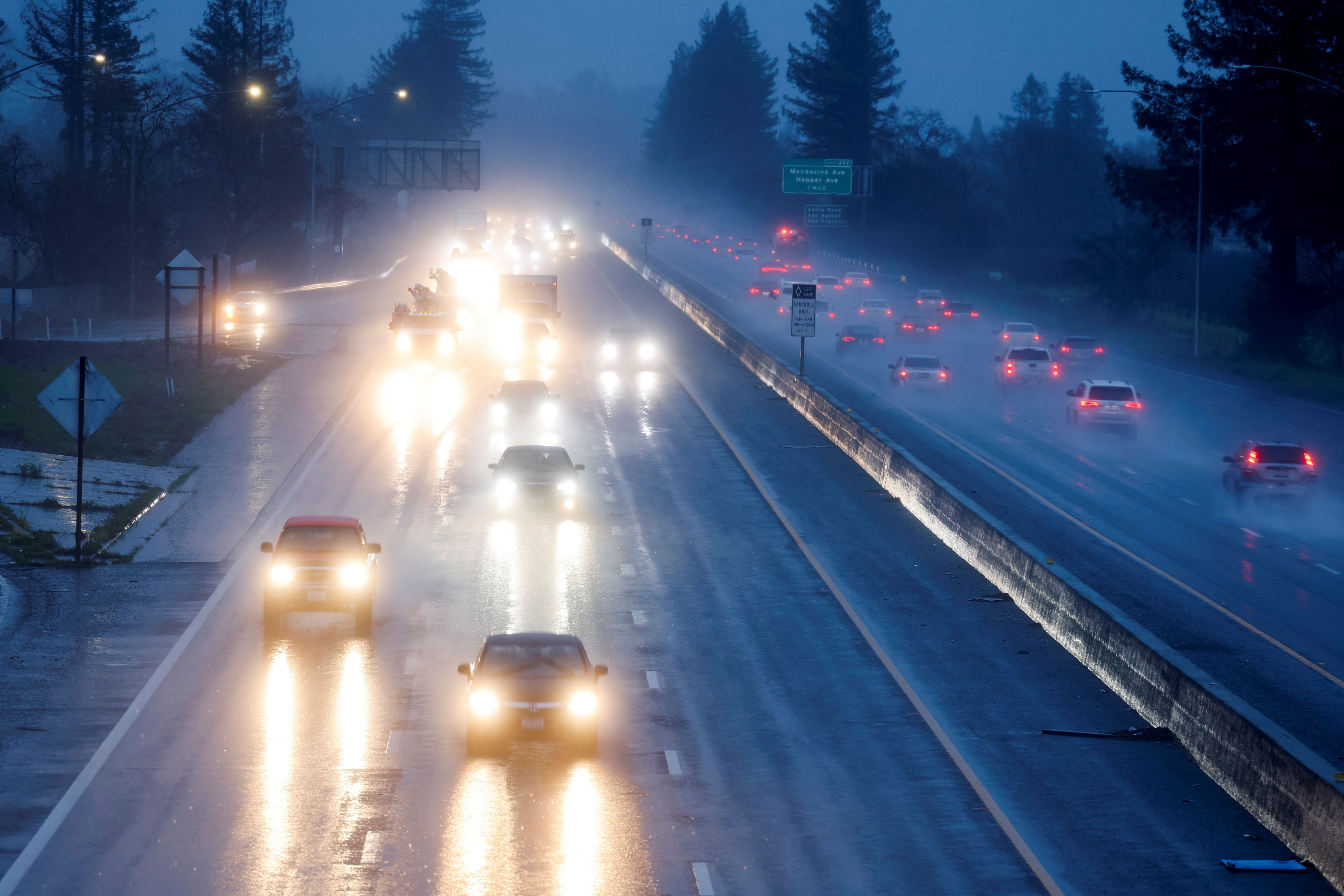 Vehicles drive in heavy rain on Highway 101 during a winter storm in Santa Rosa, California, USA.