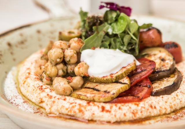 Hummus con verduras grilladas encurtidas, garbanzos en texturas, yogur griego batido y pan árabe al grill.